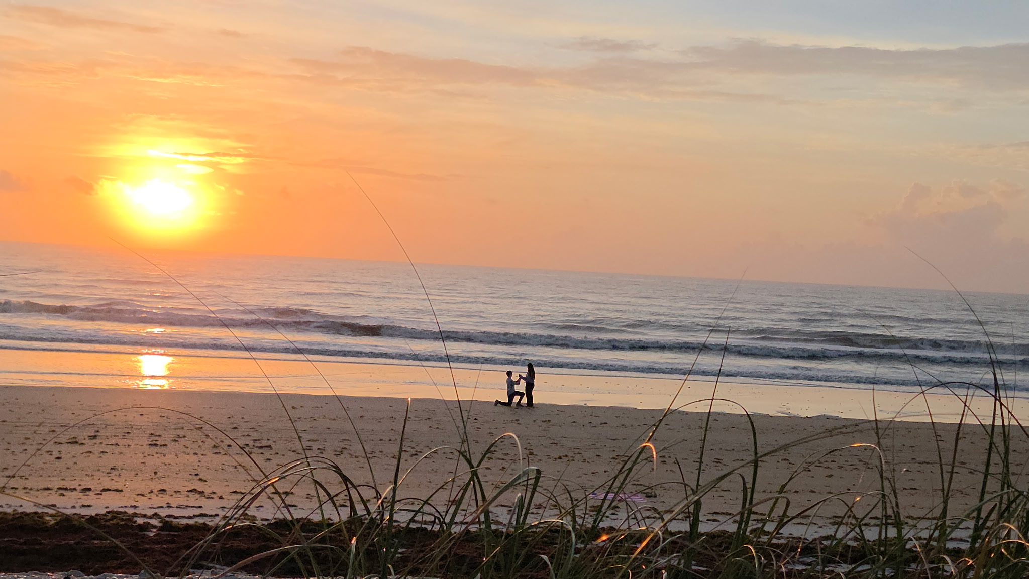 Lucas proposing to Hannah on the beach at sunrise
